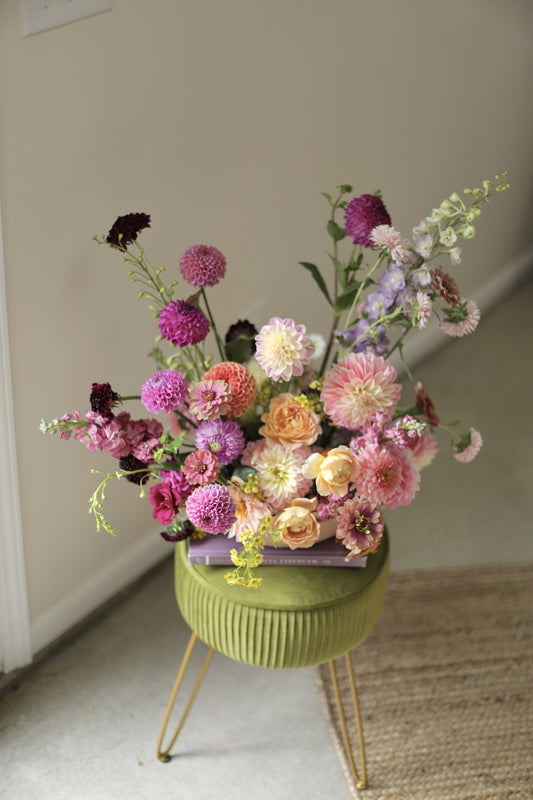 beautiful flower arrangement of summer blooms in a pink, peach and lavender palette including locally grown dahlias, garden roses