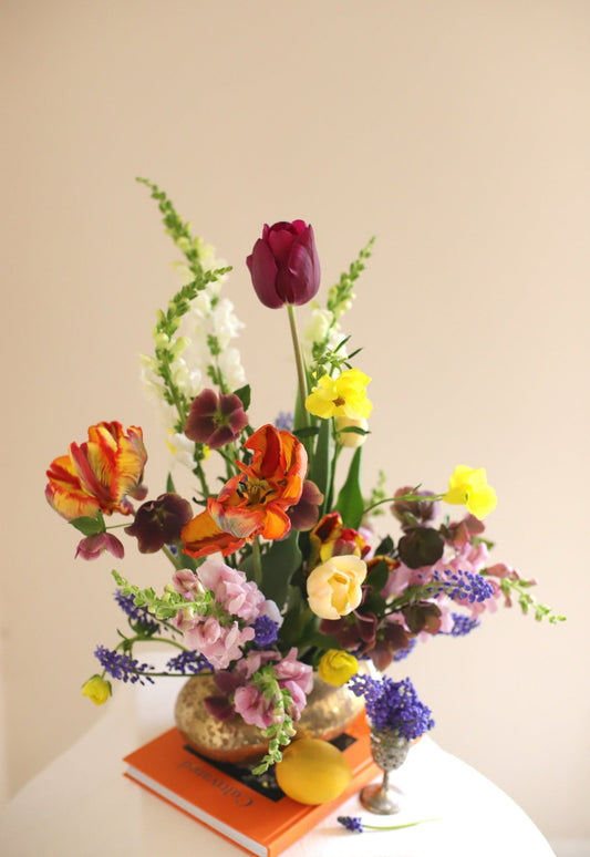 spring flower arrangement artfully designed featuring tulips, snapdragons, ranunculus in a vibrant color palette
