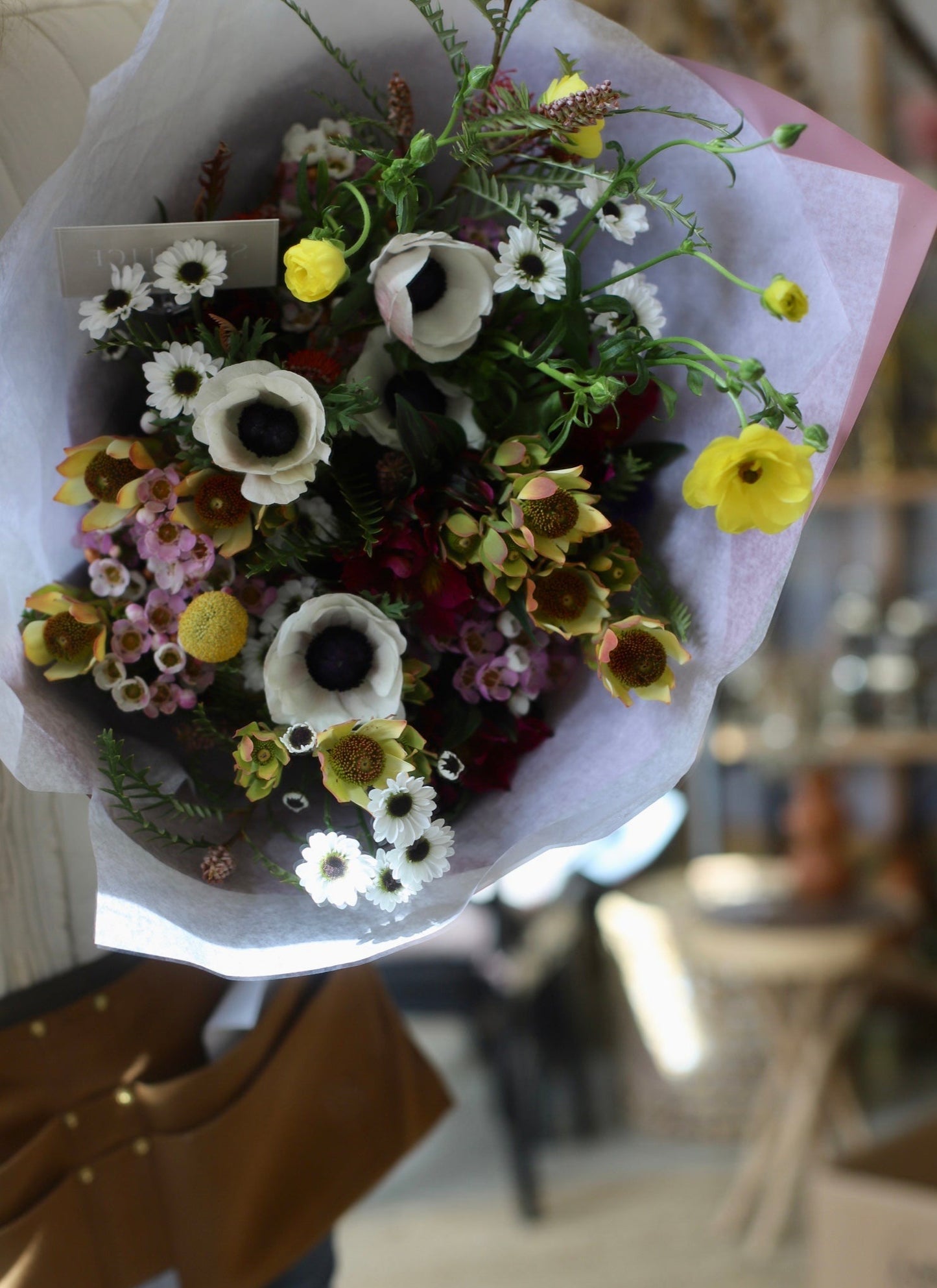 beautiful gift wrapped spring bouquet of anemones and ranunculus